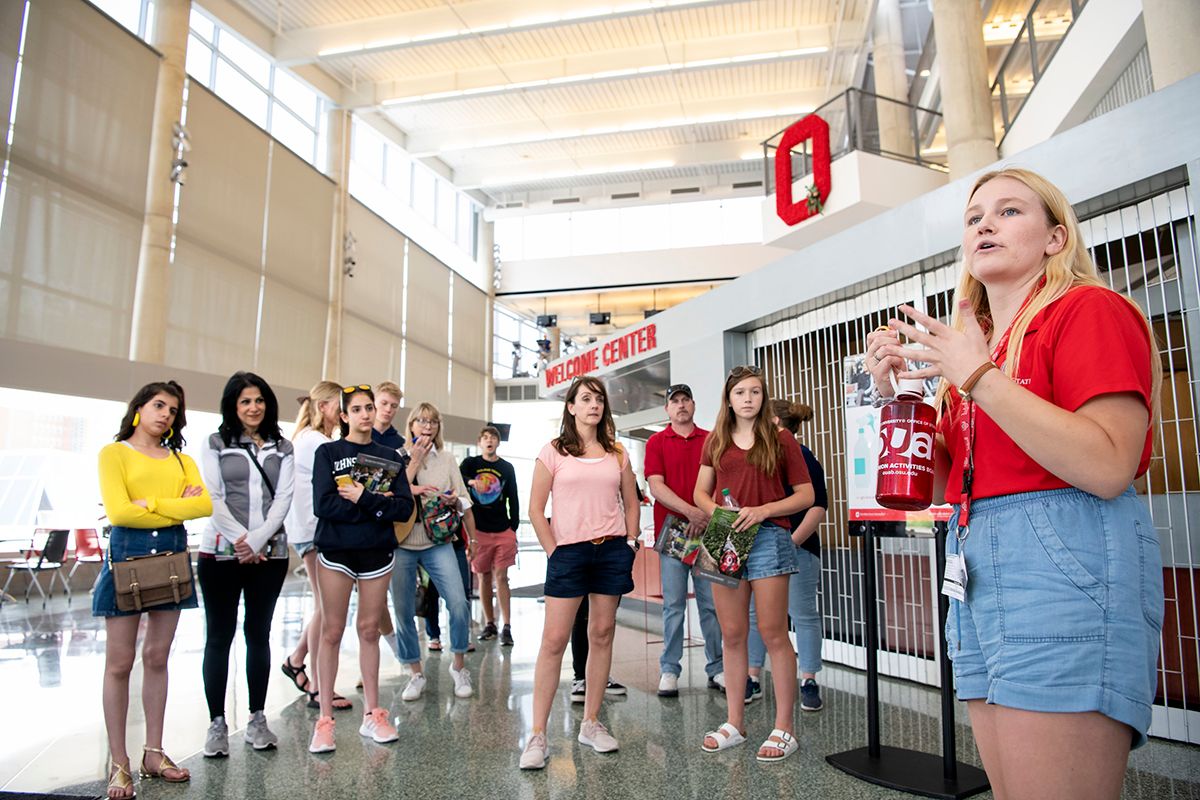 A student ambassador talks to a group of prospective students at a campus Welcome Center