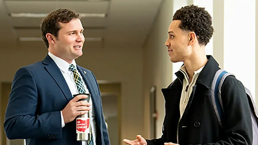 Man in a suit speaking with a student