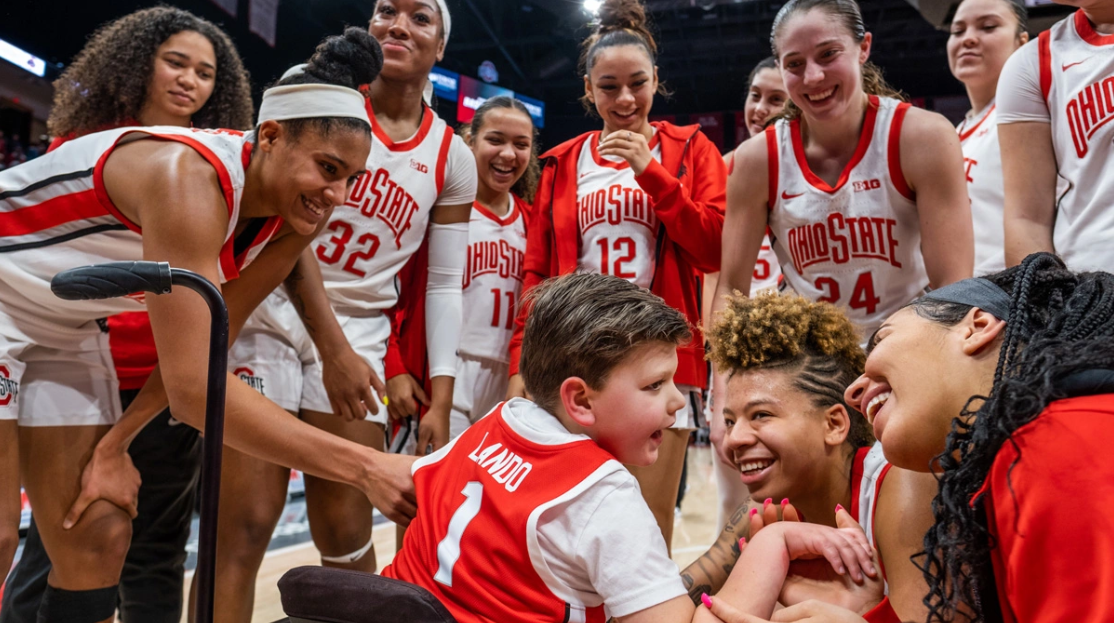 Members of the Ohio State women's basketball team smile as they greet Landon McChesney.