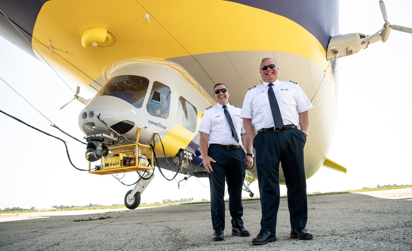 Joe Erbs and Jerry Hissem in front of the Goodyear blimp.
