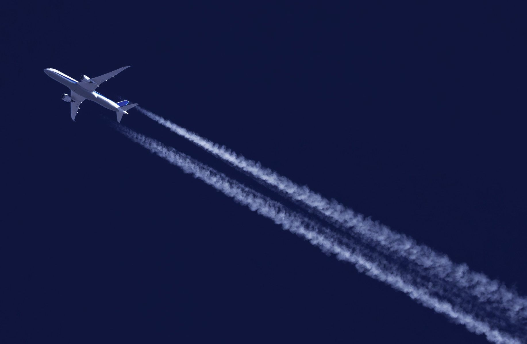 An airplane flying through a dark blue sky