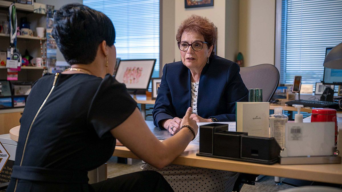 Electra Diane Paskett, PhD talking to patient at a desk