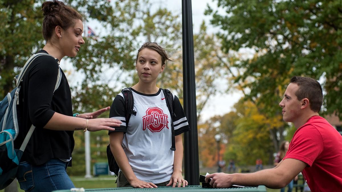 Three students talking as they stand on Ohio State’s Oval