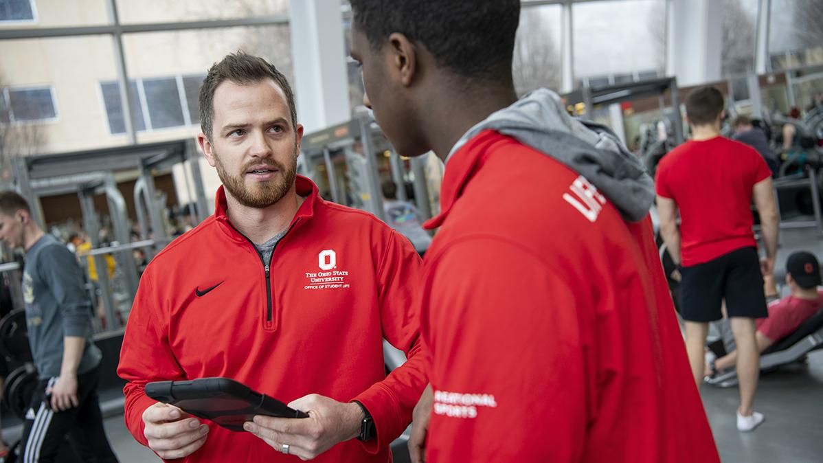 Two men in red jackets talking