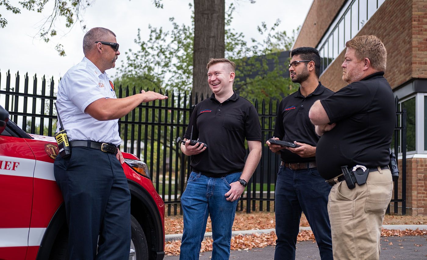 A group of men discuss how the Parawave drone team is helping first responders