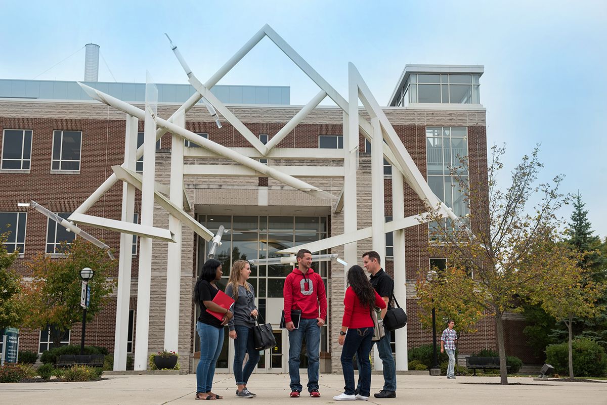 Students stand outside a building talking on the Lima campus