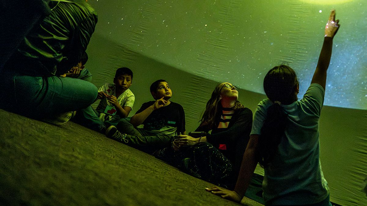Young people watch a planetarium show