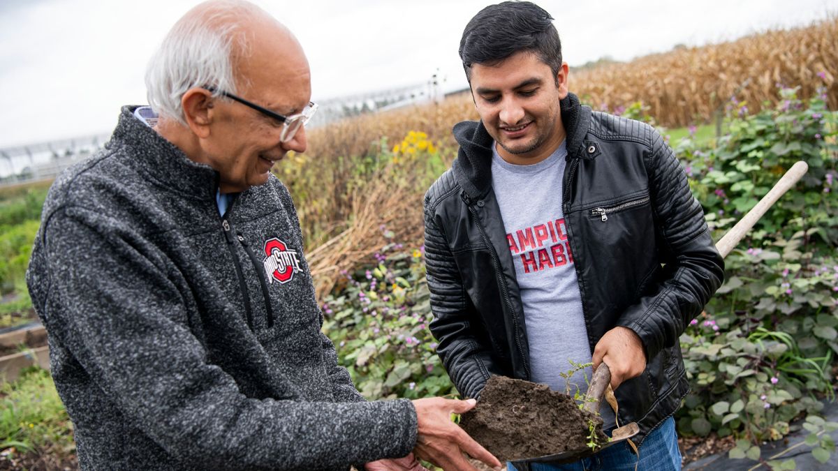 Rattan Lal inspects soil in a field