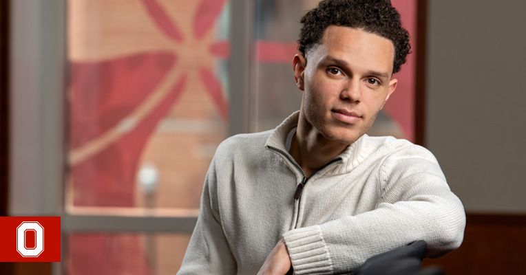 Student Christian McGhee looking at camera in a chair