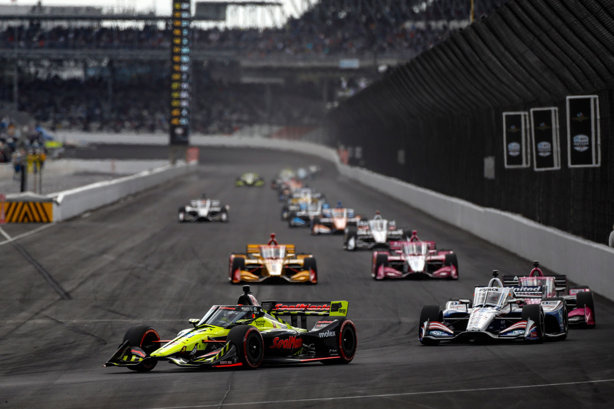 indy cars turning corner during a race