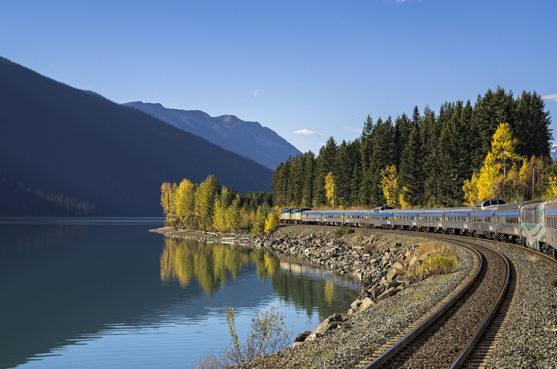 train traveling on the coast of a Canadian lake