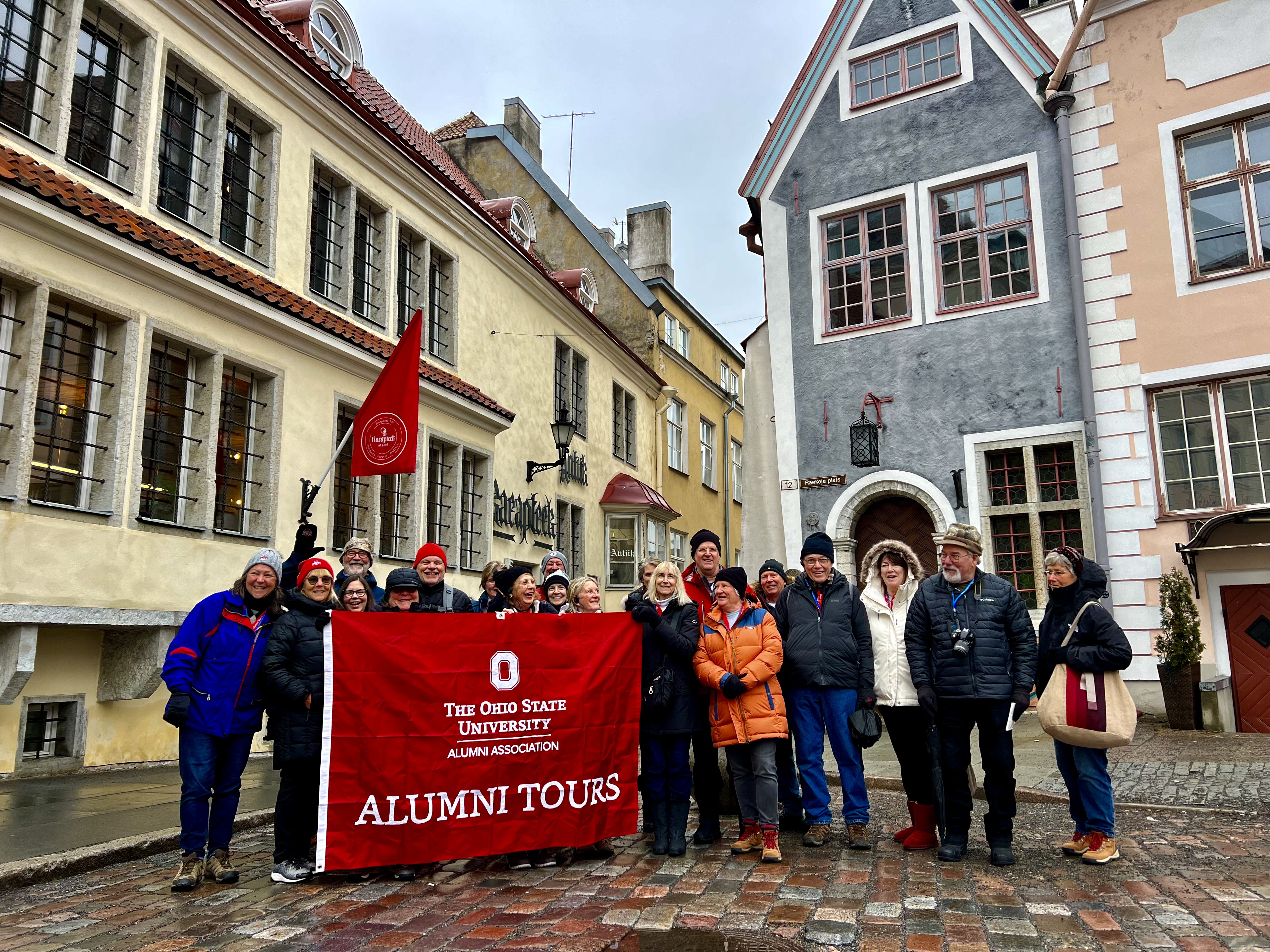 Group of Buckeye travelers holding an Ohio State Alumni Tour flag