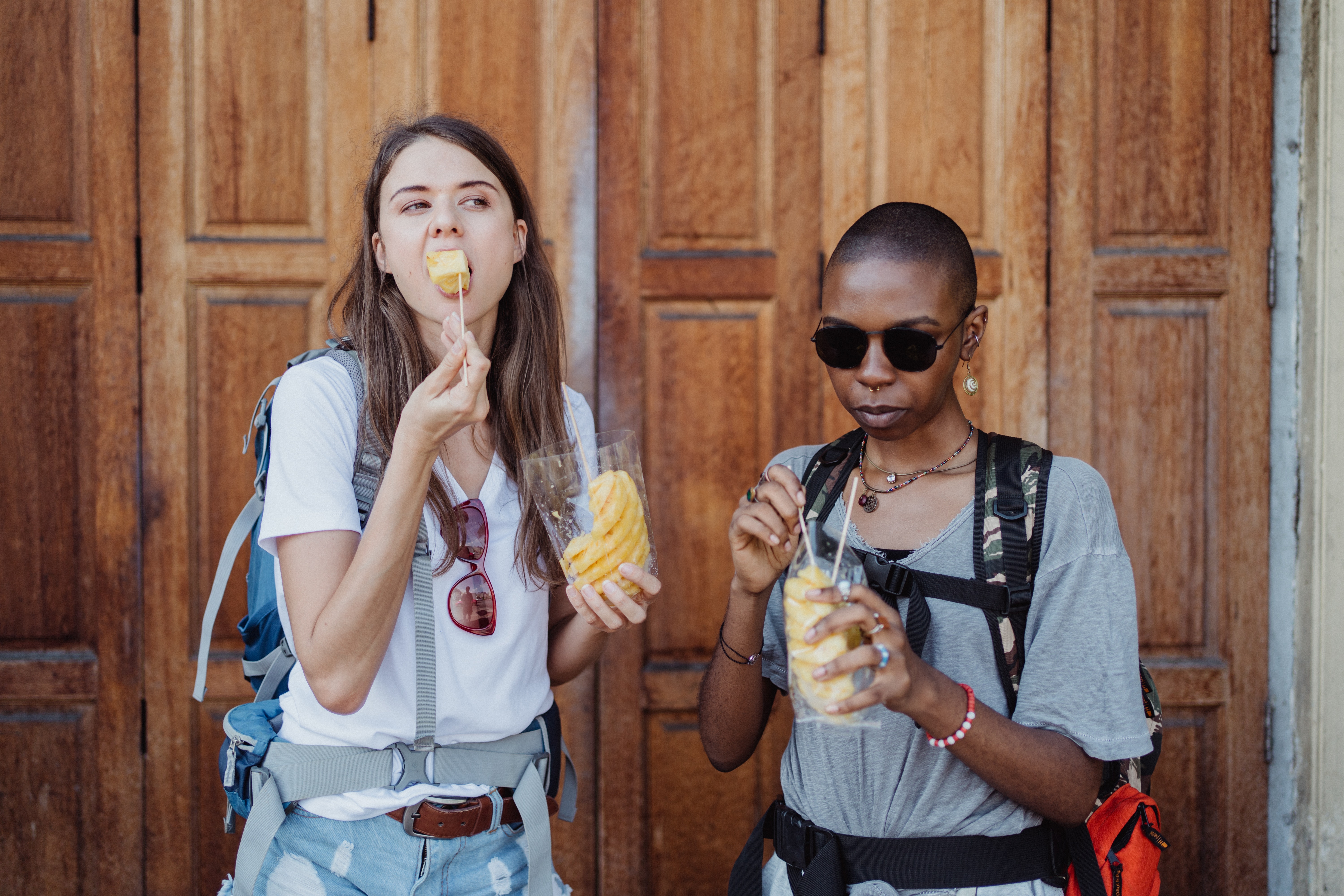 Two tour participants eating street food