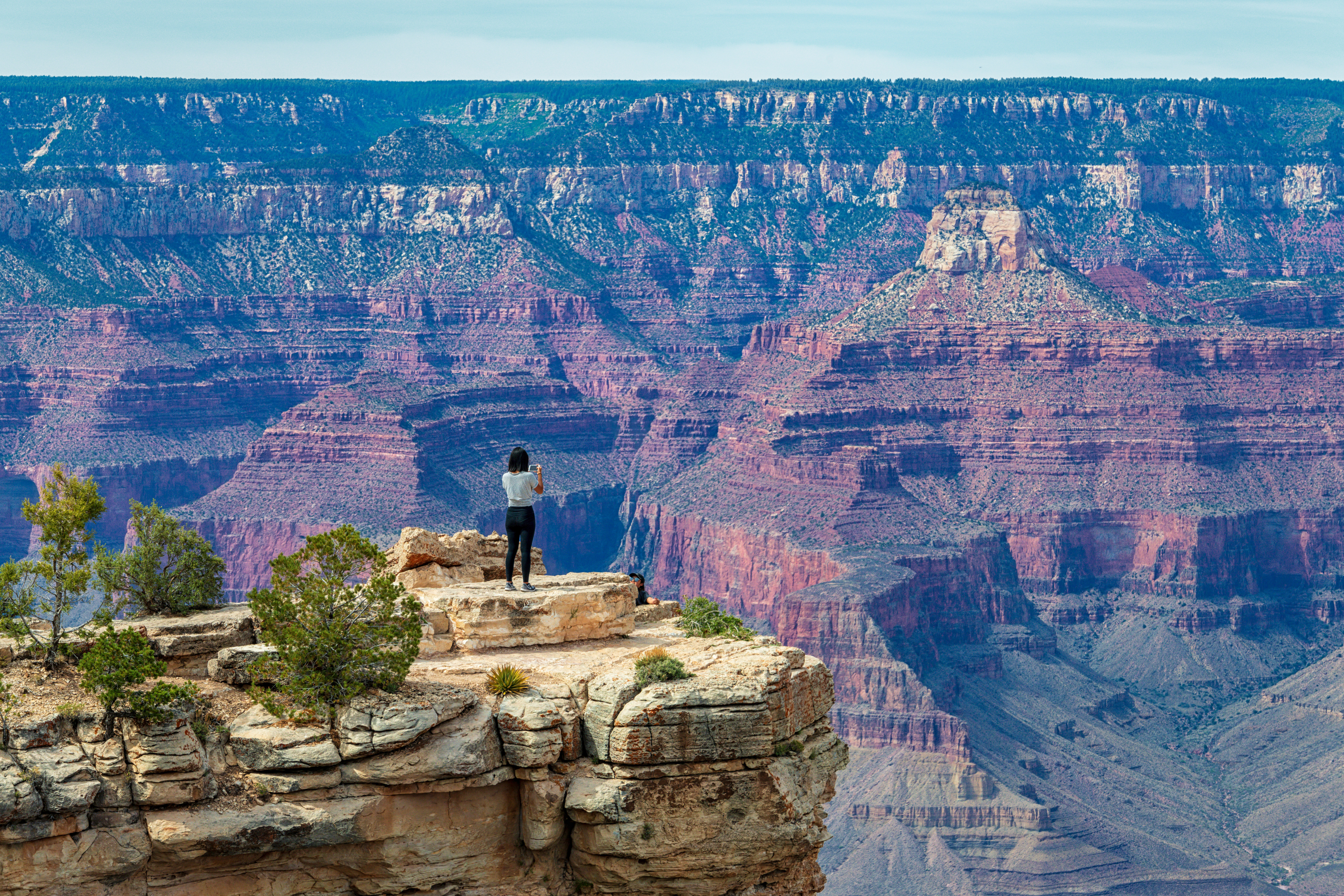Person standing on a cliff and overlooking canyons