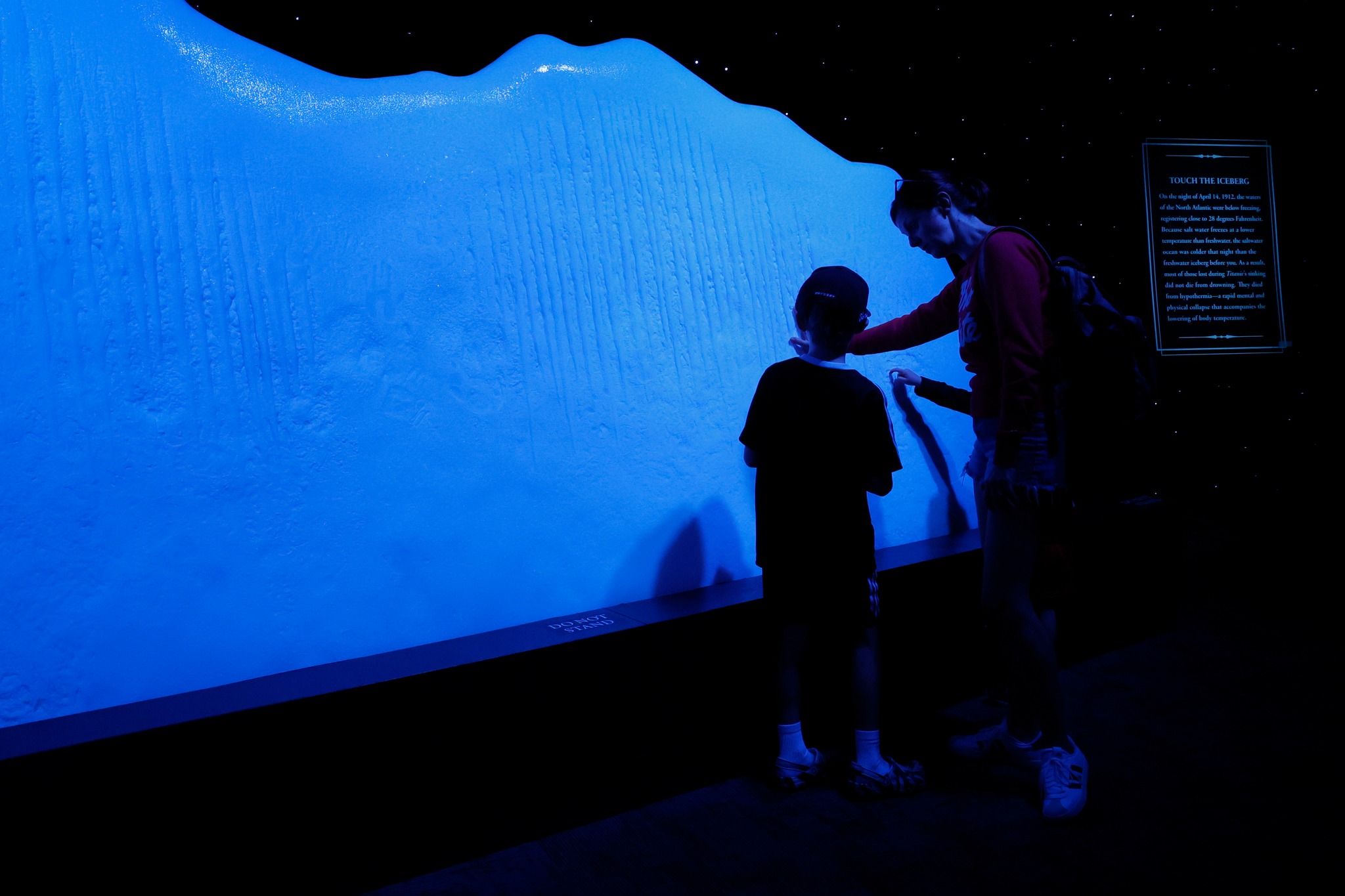 a parent shows a young child a shadow on a wall