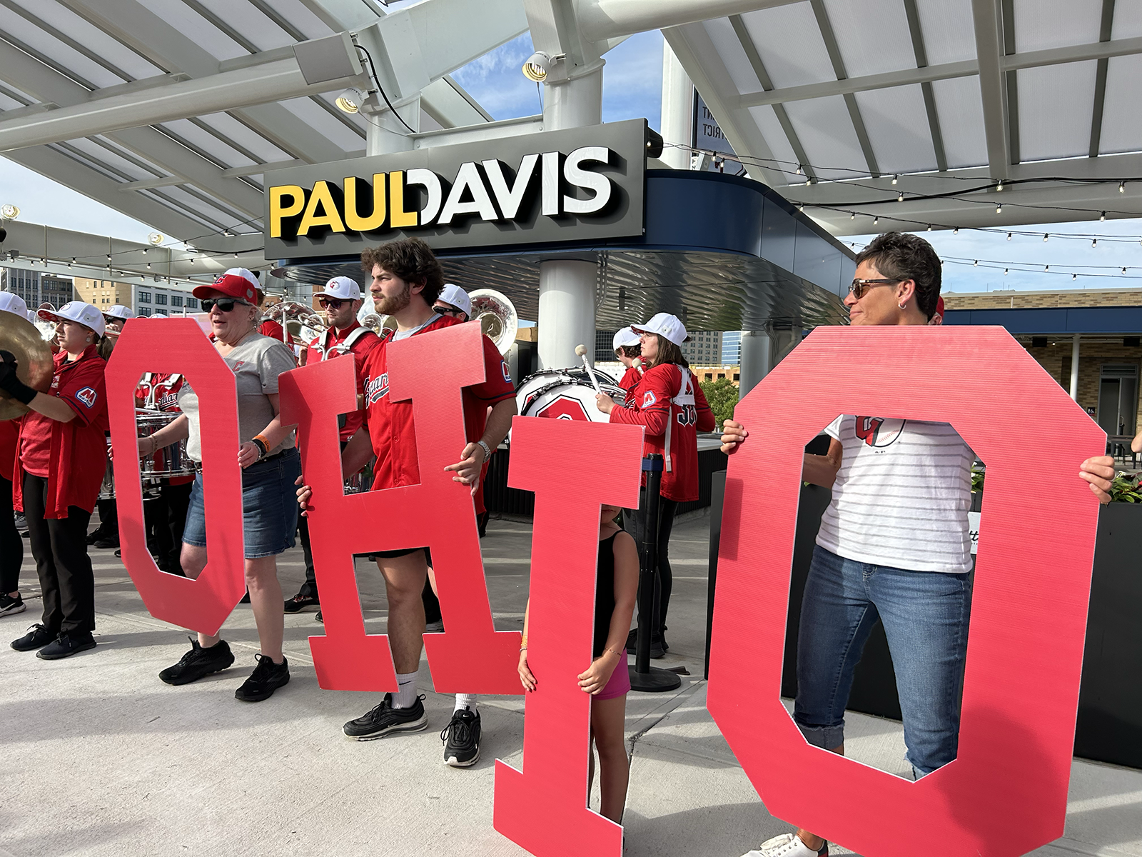four adults hold cardboard cutouts of the letters o-h-i-o