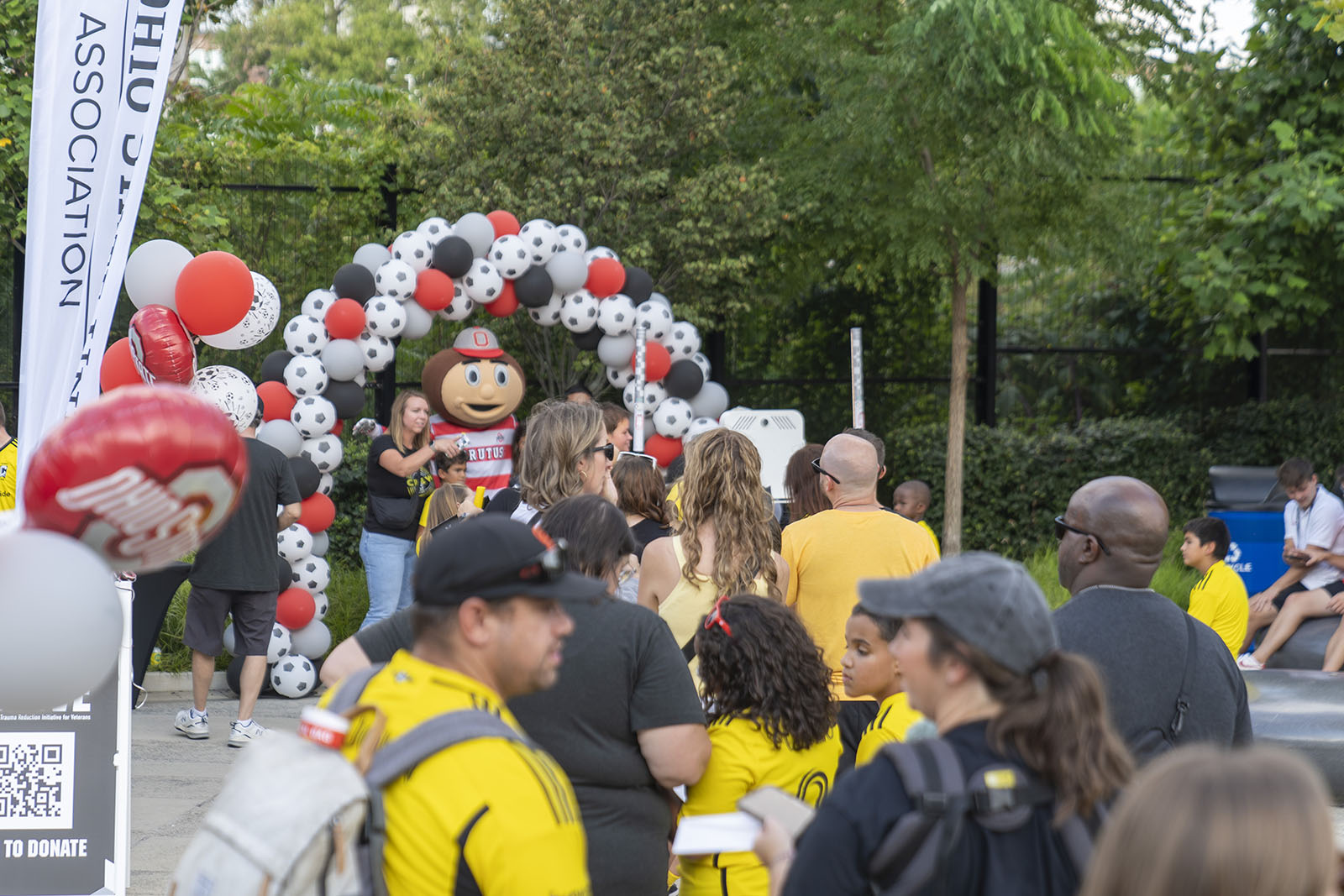 Brutus Buckeye playfully taking photos with people