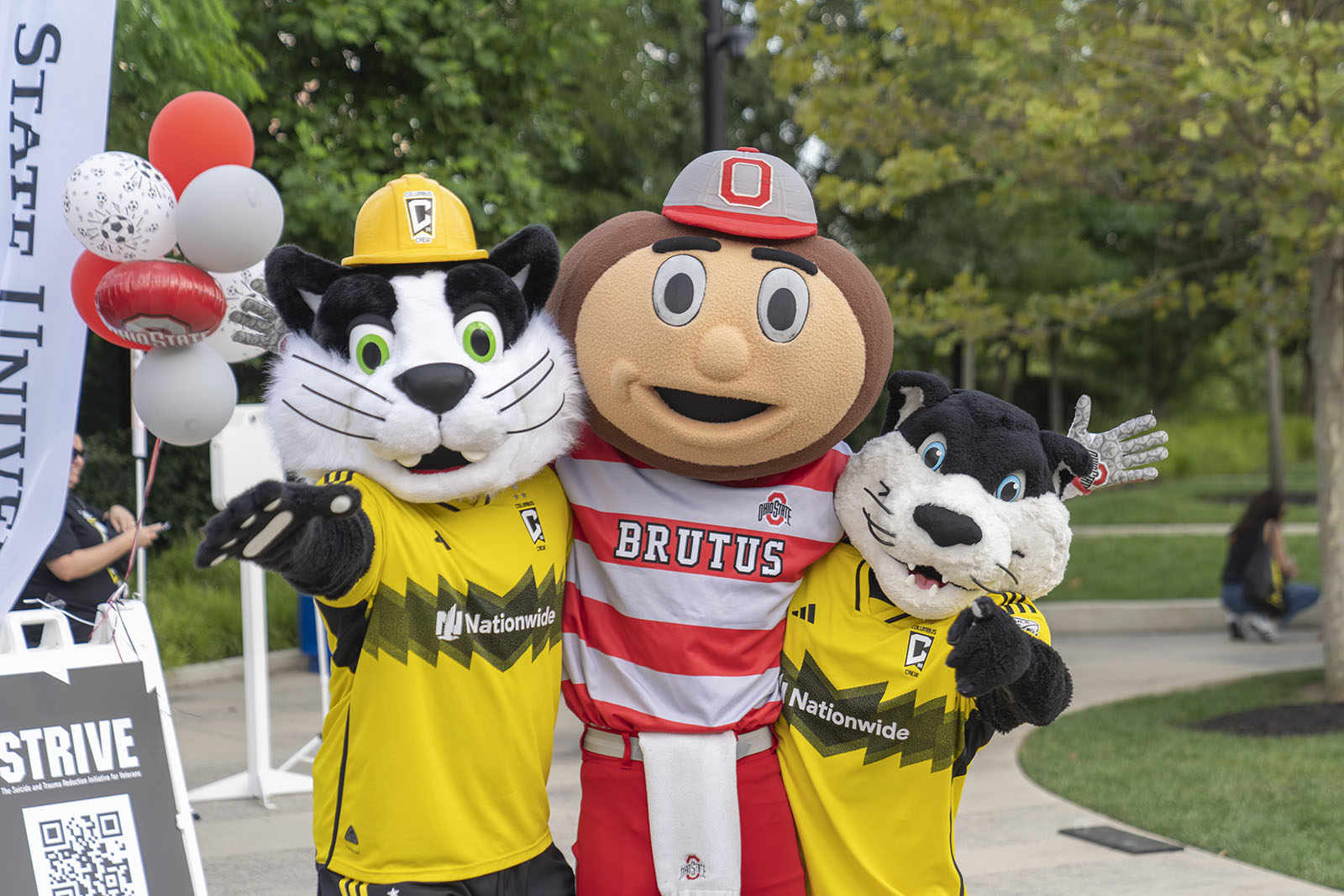 Mascots Brutus Buckeye, Crew Cat and S.C. pose arm-in-arm