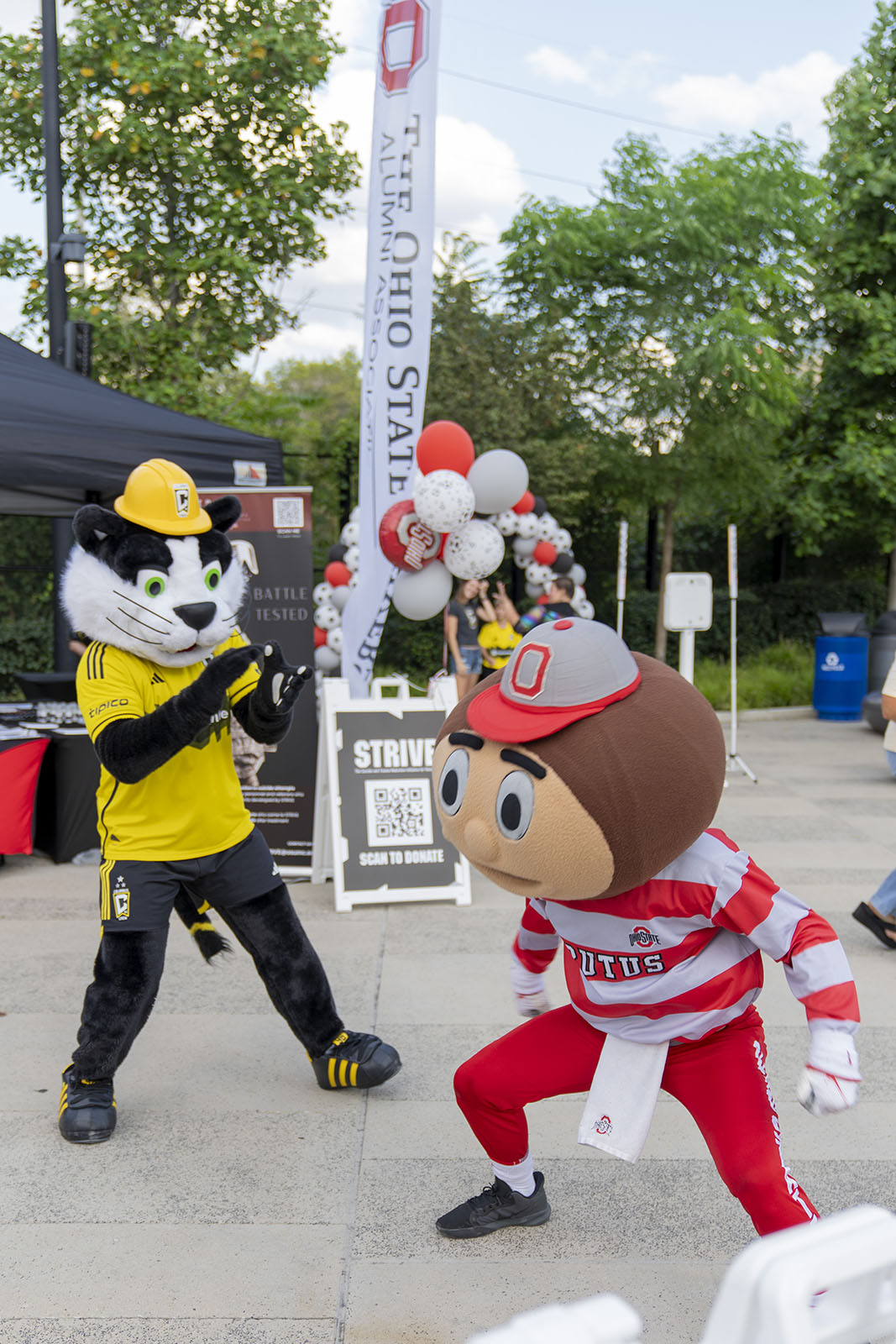 Brutus Buckeye and Crew Cat playfully interact with people