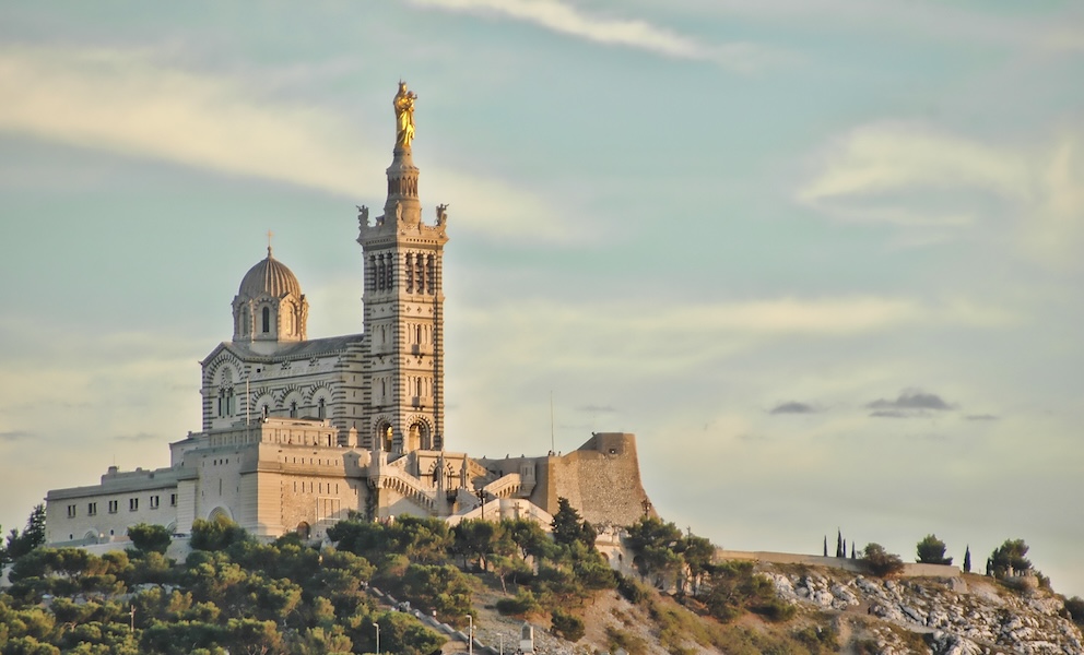 A large historical building perched on a hill at sunset