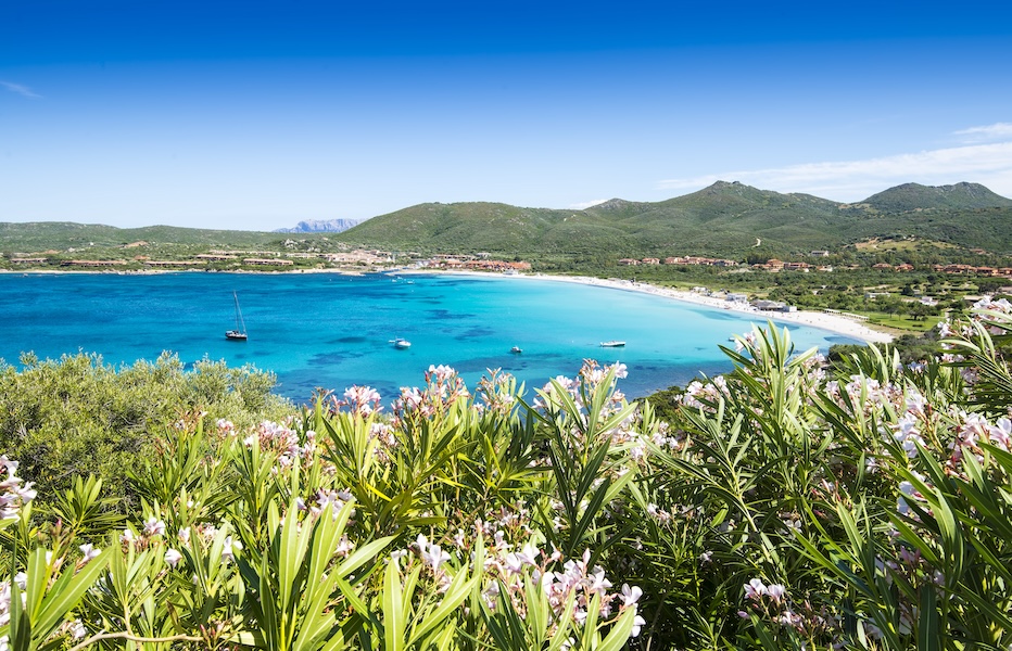 Bright turquoise waters with white beaches surrounded by lush green hills