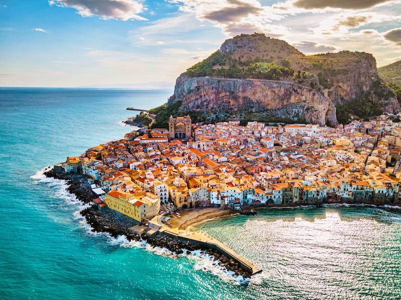 The harbor and heavily populated coastline of Sicily surrounded by turquoise waters