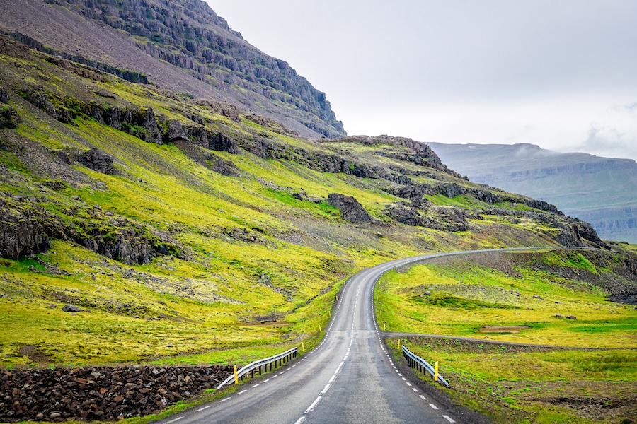 a road through a lush green hilly countryside
