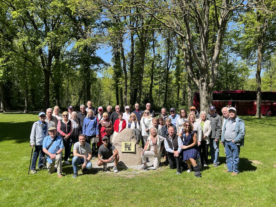 Tour group photo with large trees in background