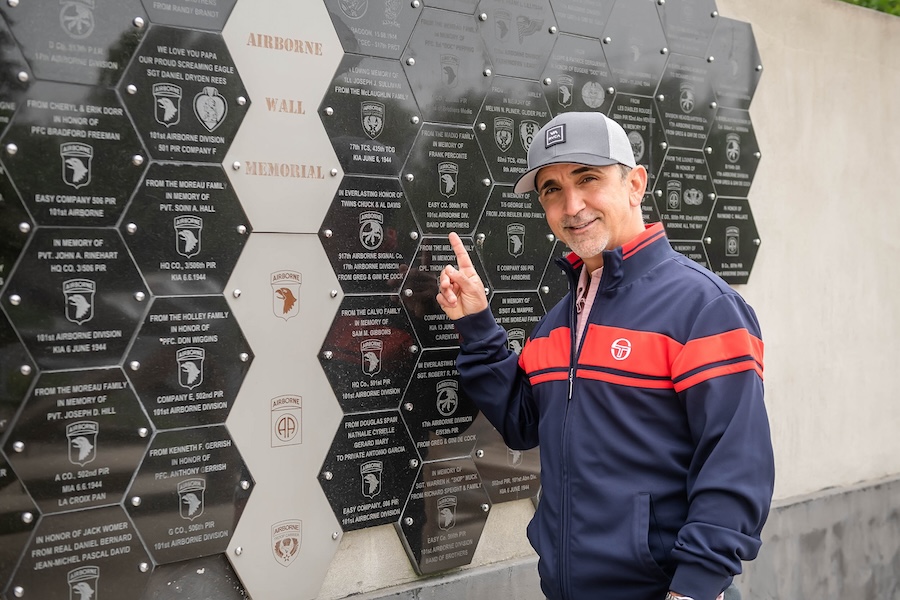 Traveler pointing to a memorial wall