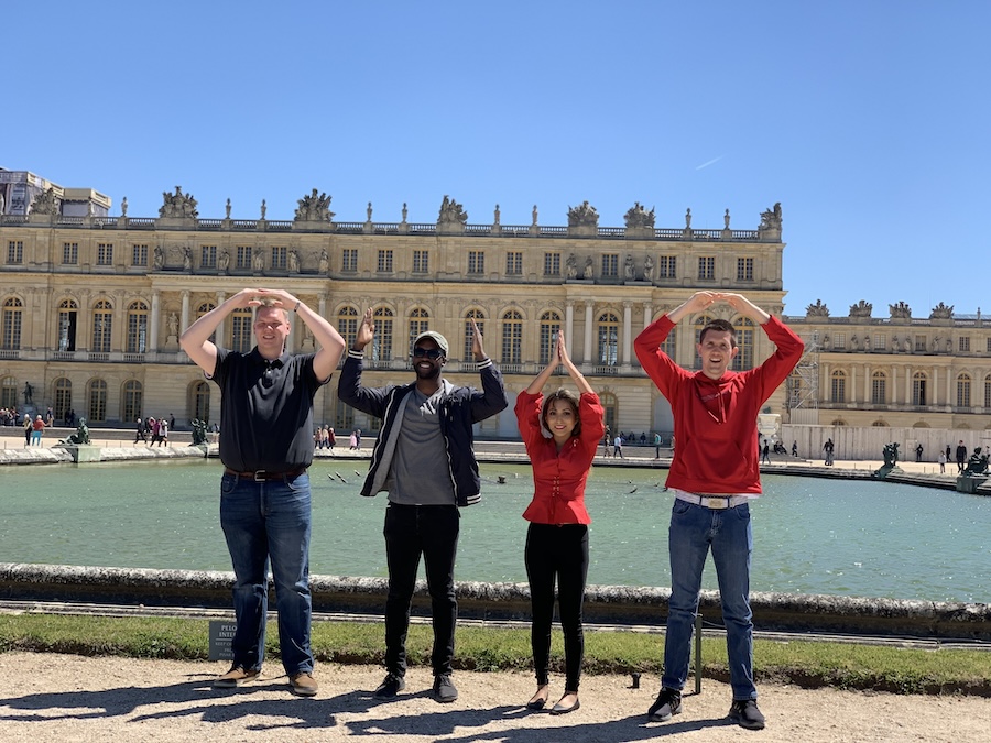 Travelers doing O-H-I-O in front of a building in Europe