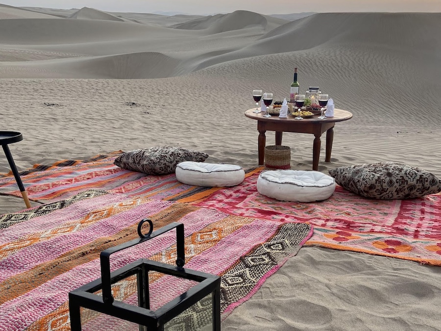 Blankets and tables in the middle of sand dunes