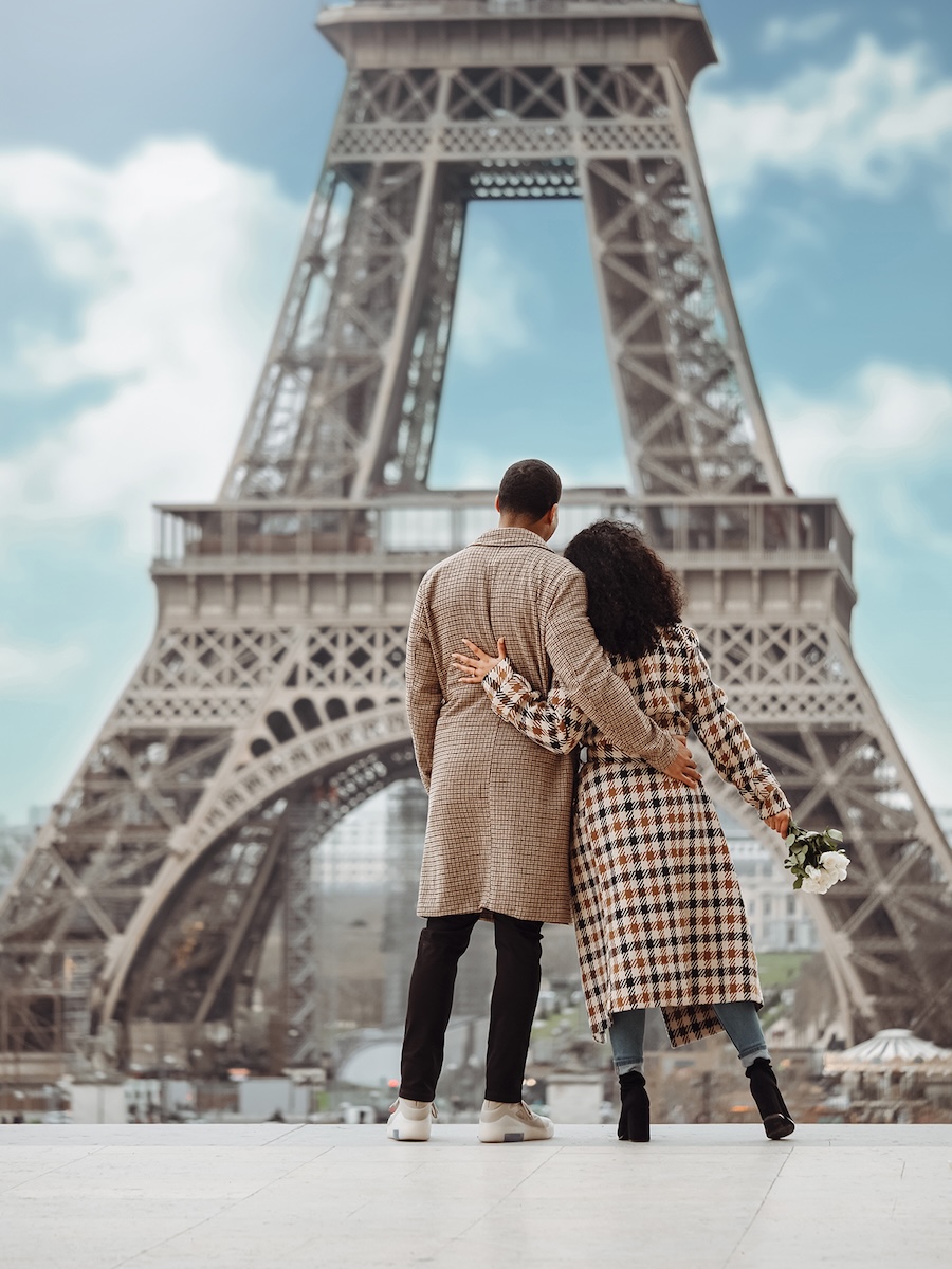 Two people hugging in front of the Eiffel Tower