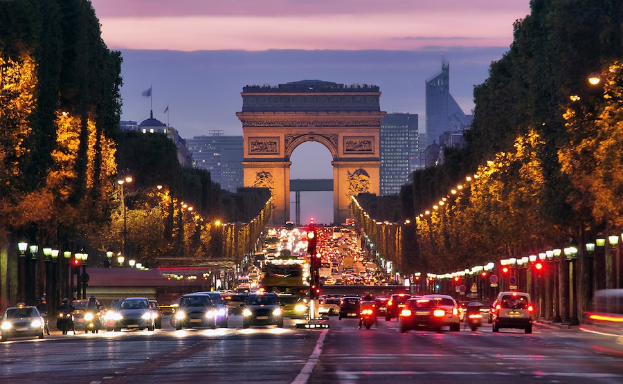 A busy Paris street lit up at night