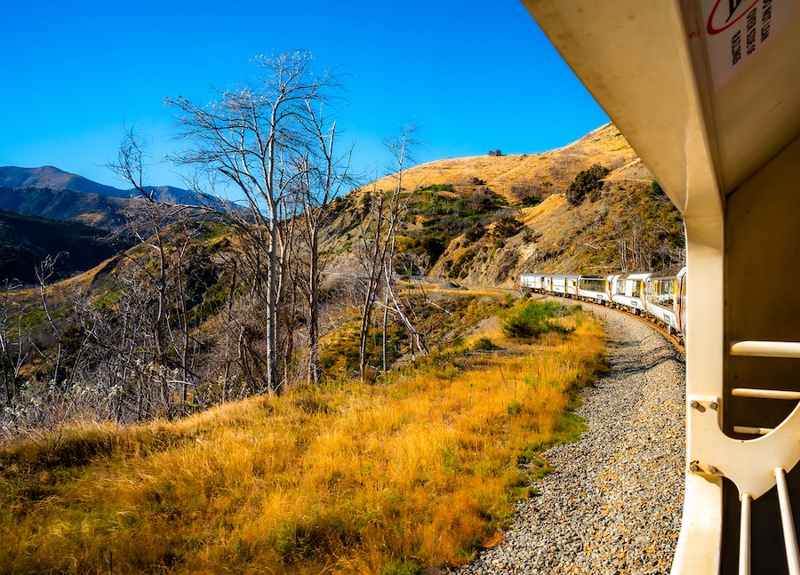 A view of the hilly terrain from a train car
