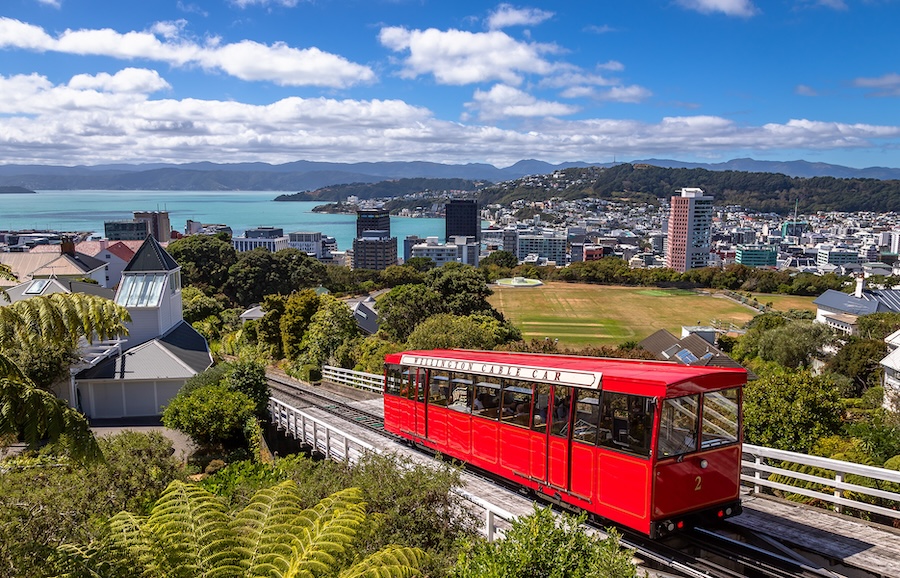 A red train car driving near the town of Wellington