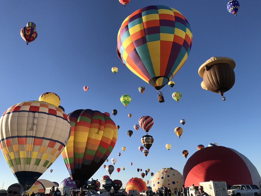Dozens of hot air balloons floating in the sky
