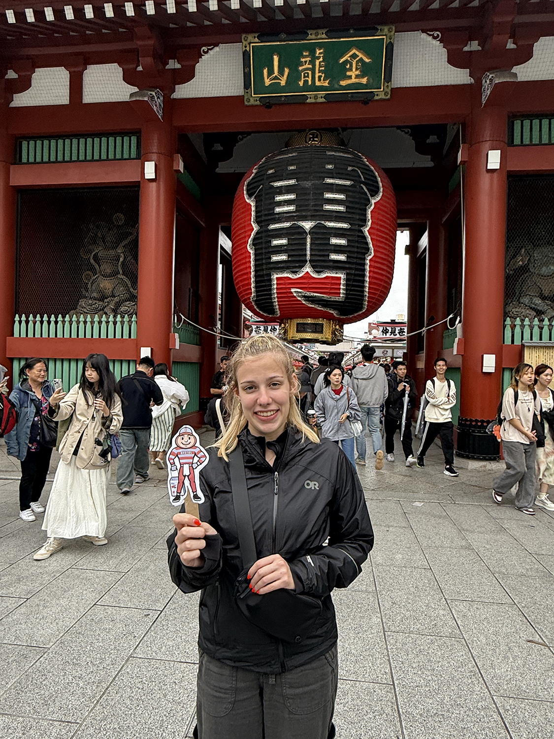 Woman holding Brutus in front of the Kaminarimon Gate at Senso-ji Temple in Tokyo, Japan.