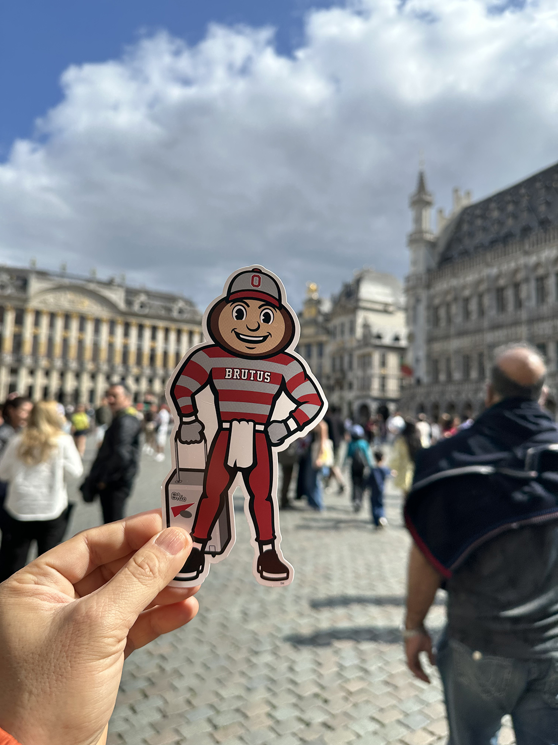 Brutus in a busy plaza with historic buildings in the background in Brussels, Belgium.