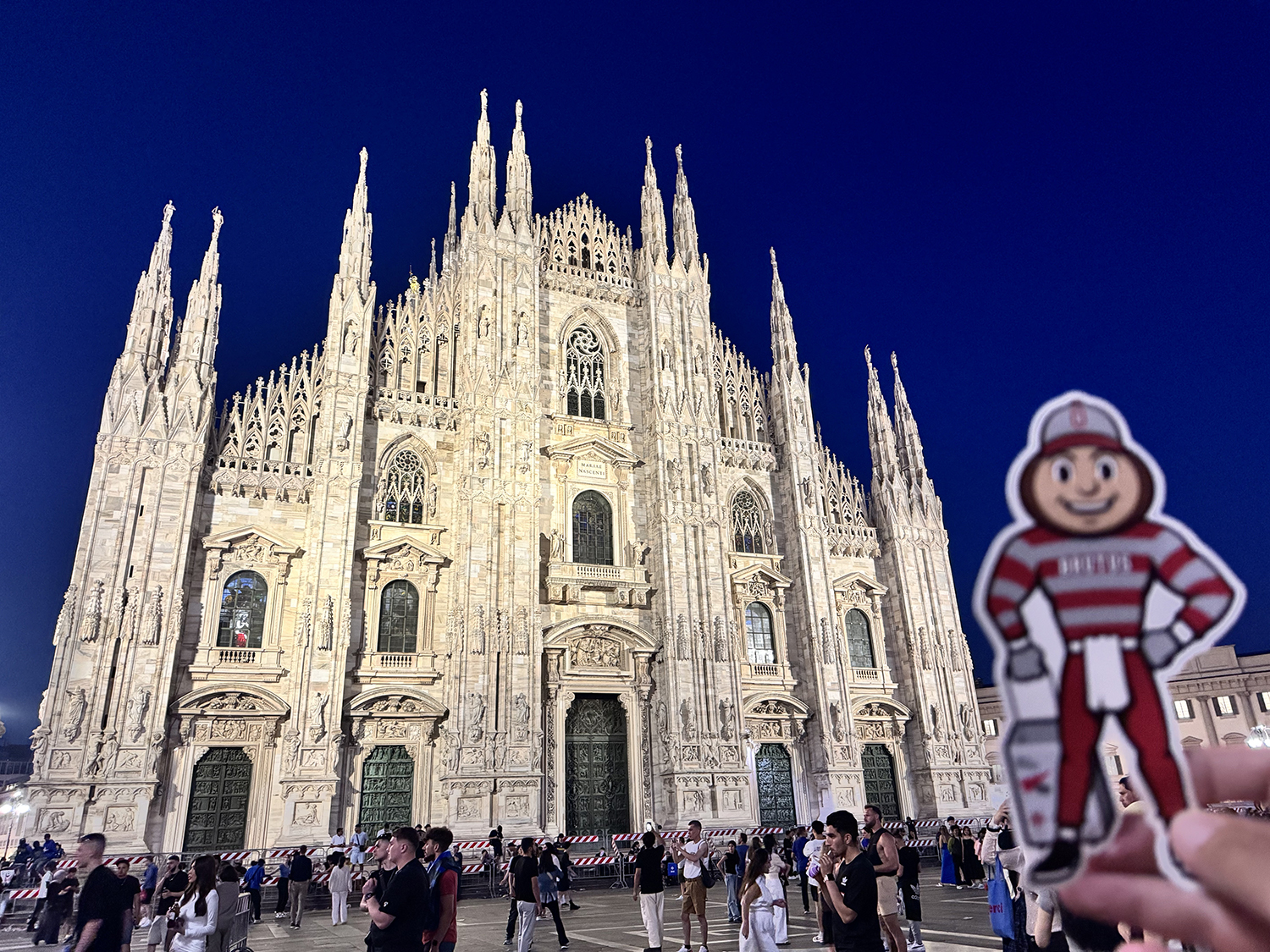 Brutus in front of the Duomo di Milano at night in Milan, Italy.