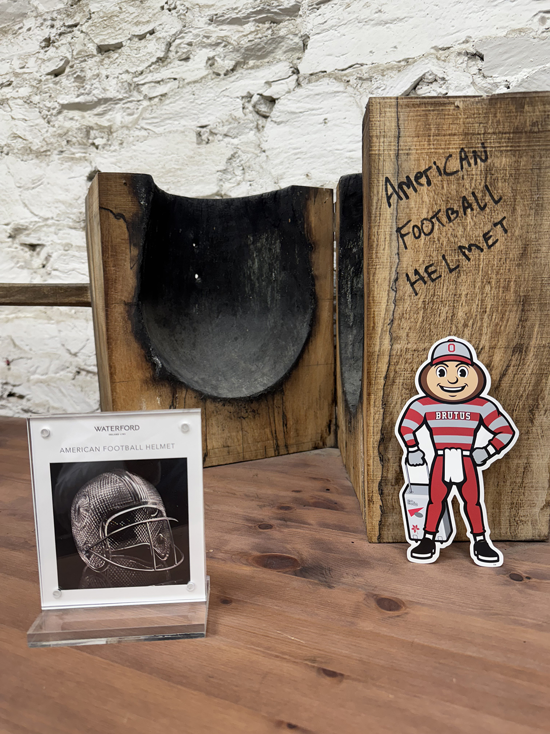 Brutus in front of a wood cast mold with a sign that says "Waterford – American Football Helmet" in Waterford, Ireland.