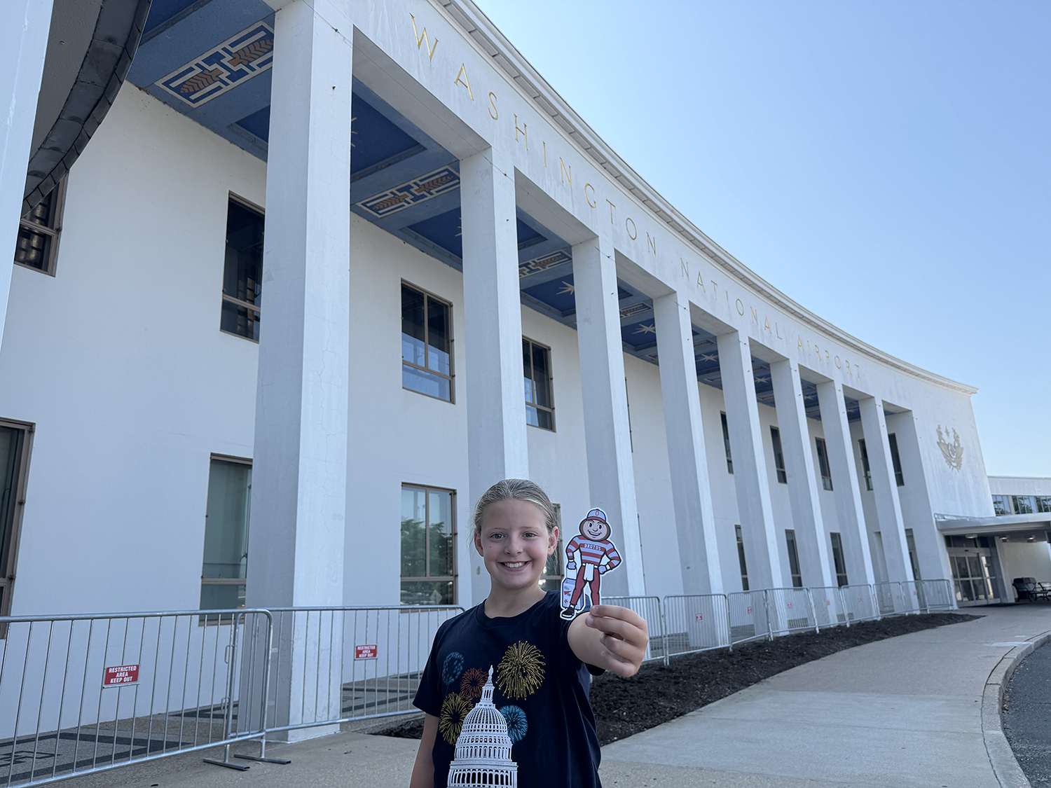 A girl holding Brutus in front of the Washington National Airport in Washington, D.C.
