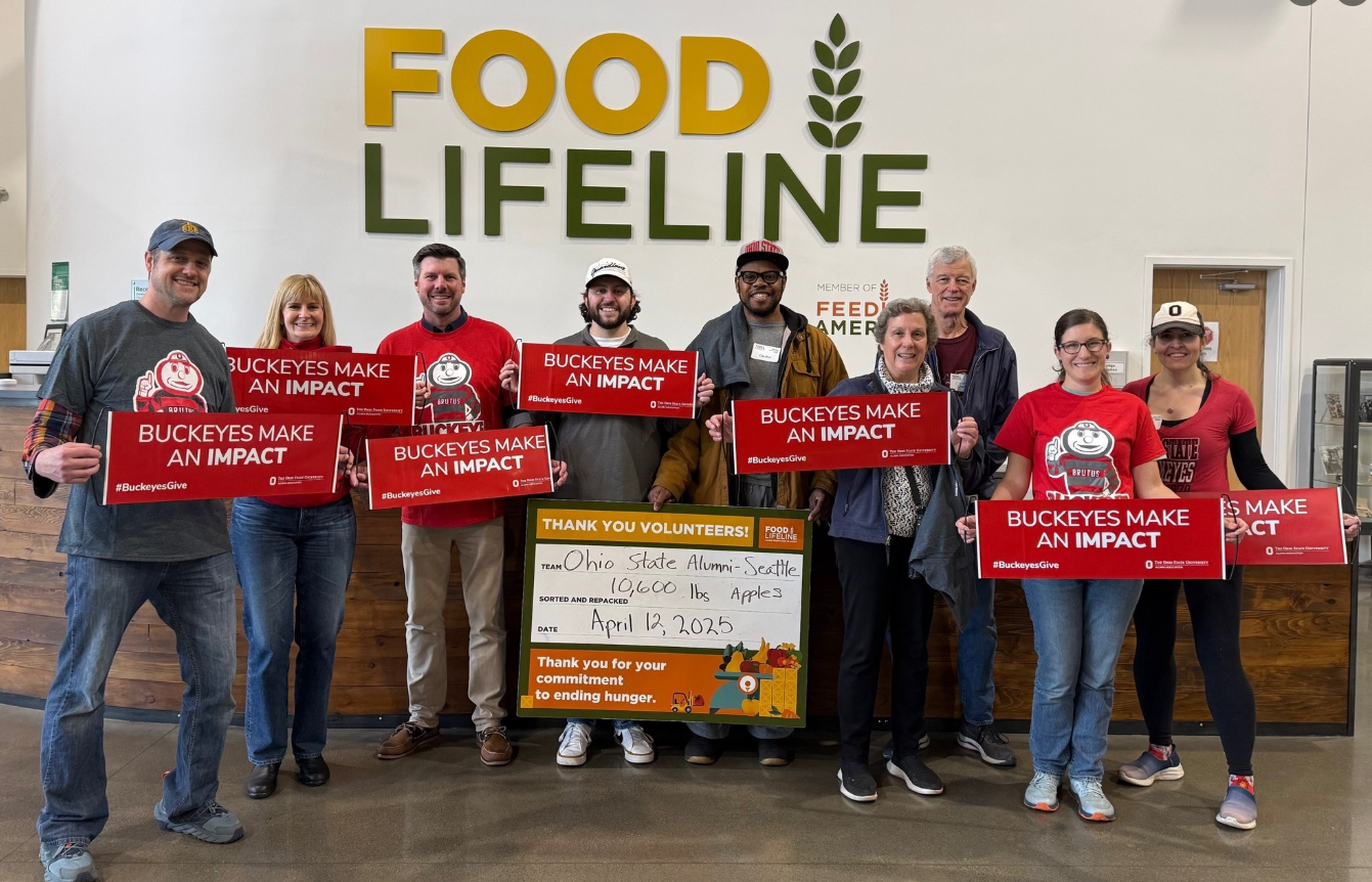 seattle club members gathering at a volunteer event holding buckeyes make an impact sign