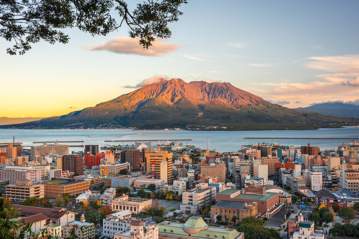 Kagoshima city skyline with a large volcanic mountain rising across the bay.