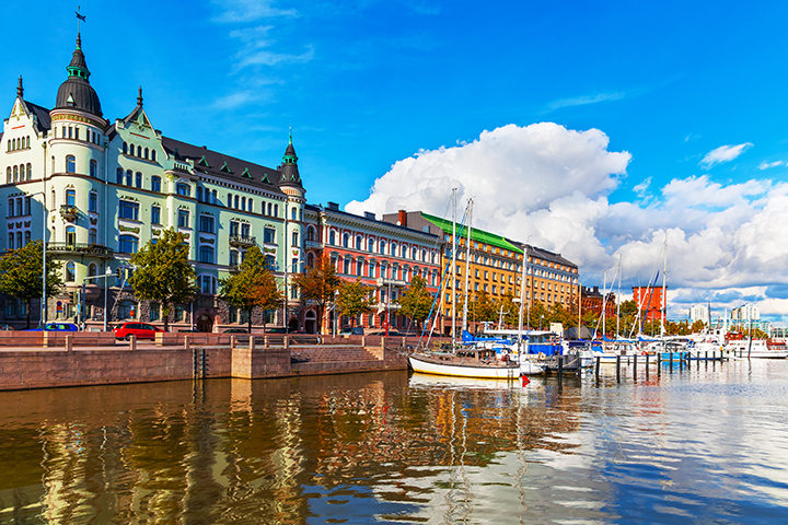 Pastel buildings in Helsinki overlooking a marina filled with sailboats.