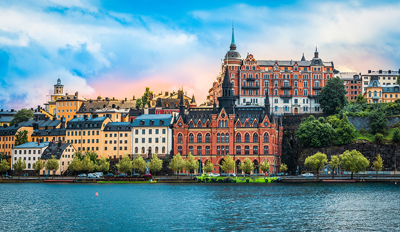 Historic waterfront buildings reflected in the water in Stockholm.
