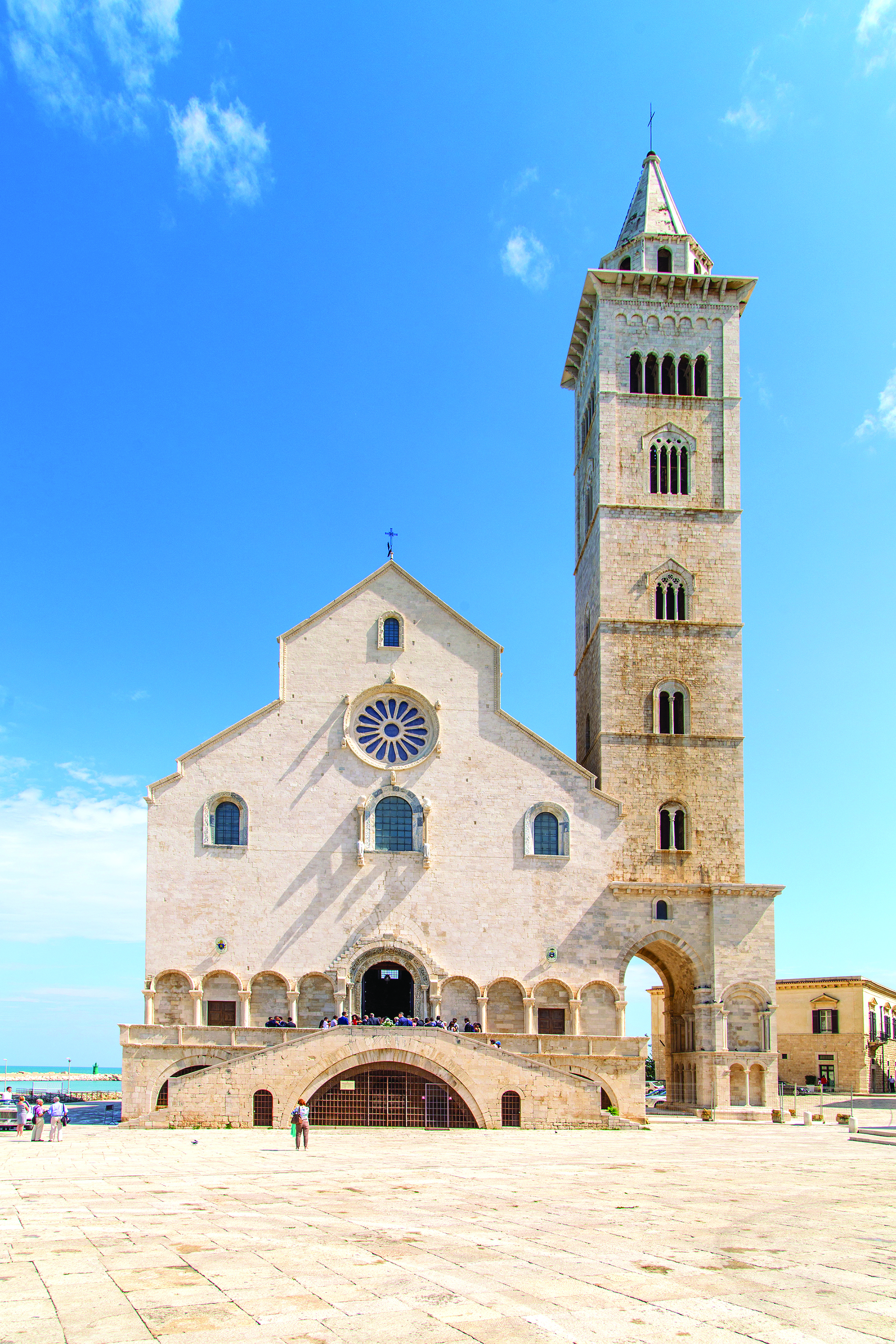Trani Cathedral of St. Nicholas the Pilgrim standing near the Adriatic coast under a clear blue sky.