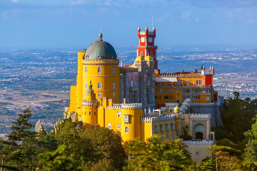 Pena Palace in Sintra, Portugal, a vibrant hilltop castle with colorful architecture, surrounded by lush greenery and stunning views.