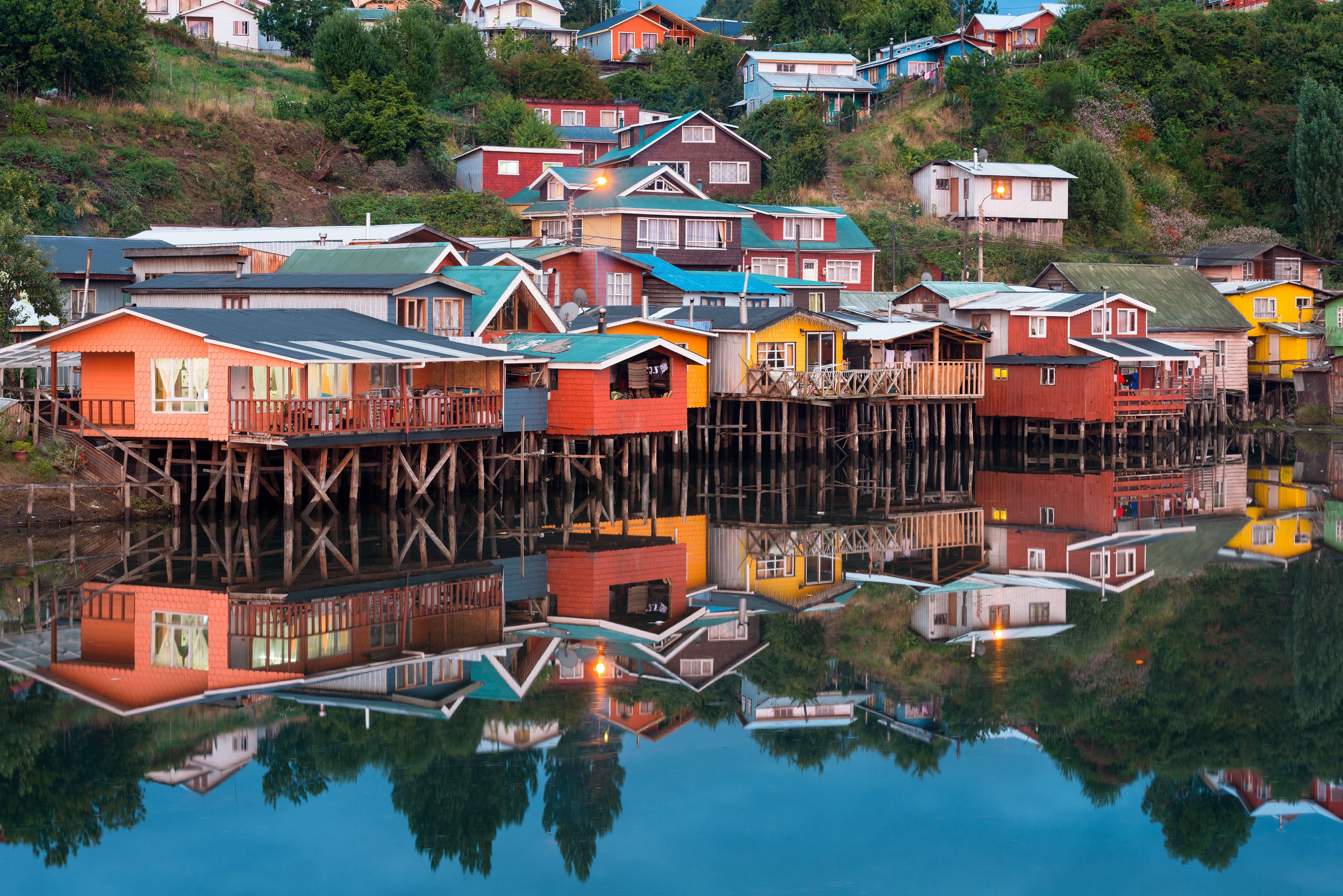Colorful traditional stilt houses, known as palafitos, lining the waterfront in the city of Castro on Chiloé Island, Southern Chile.