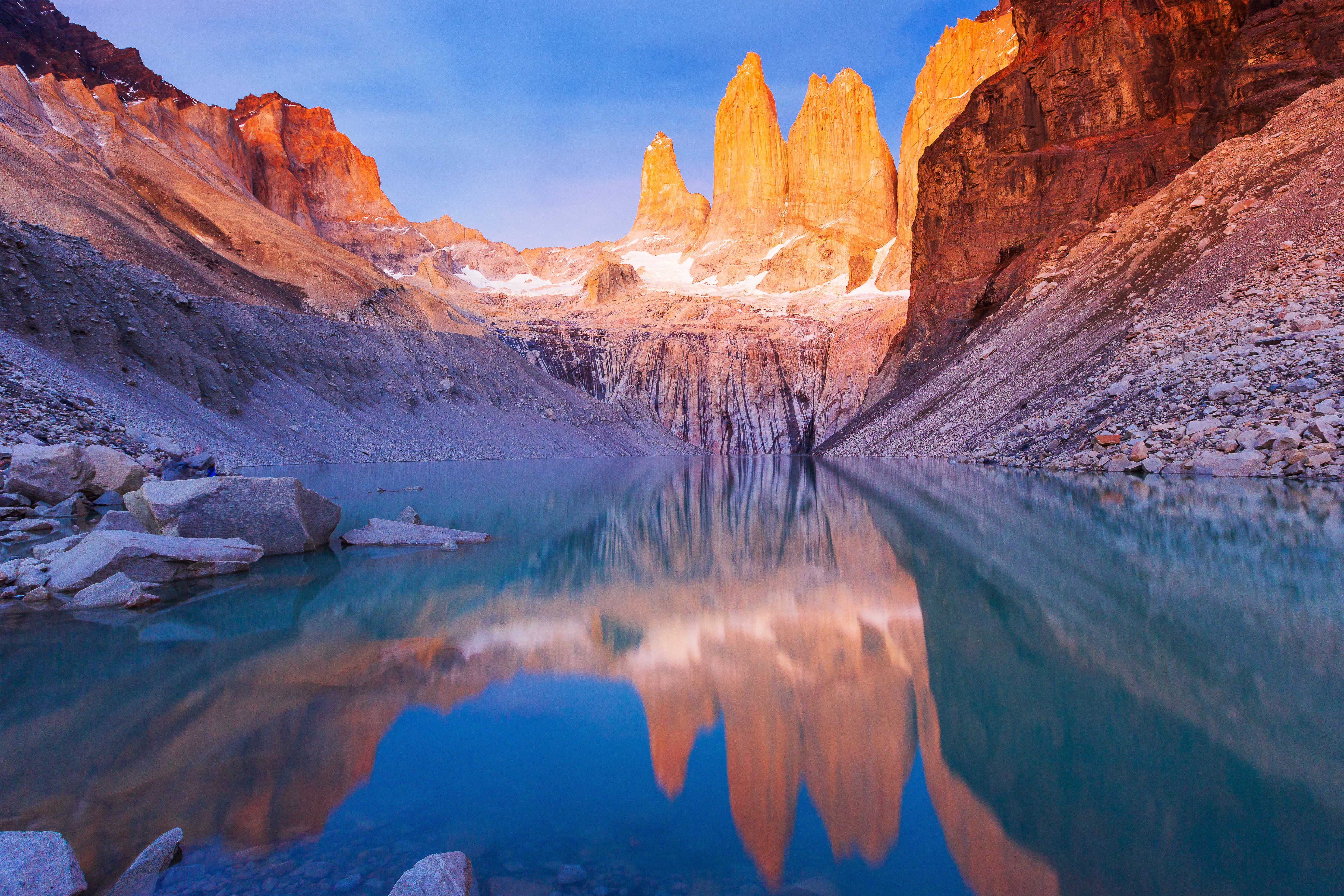 Dramatic dawn over Torres del Paine National Park in Chile, with vibrant colors lighting up rugged mountain peaks and misty valleys.