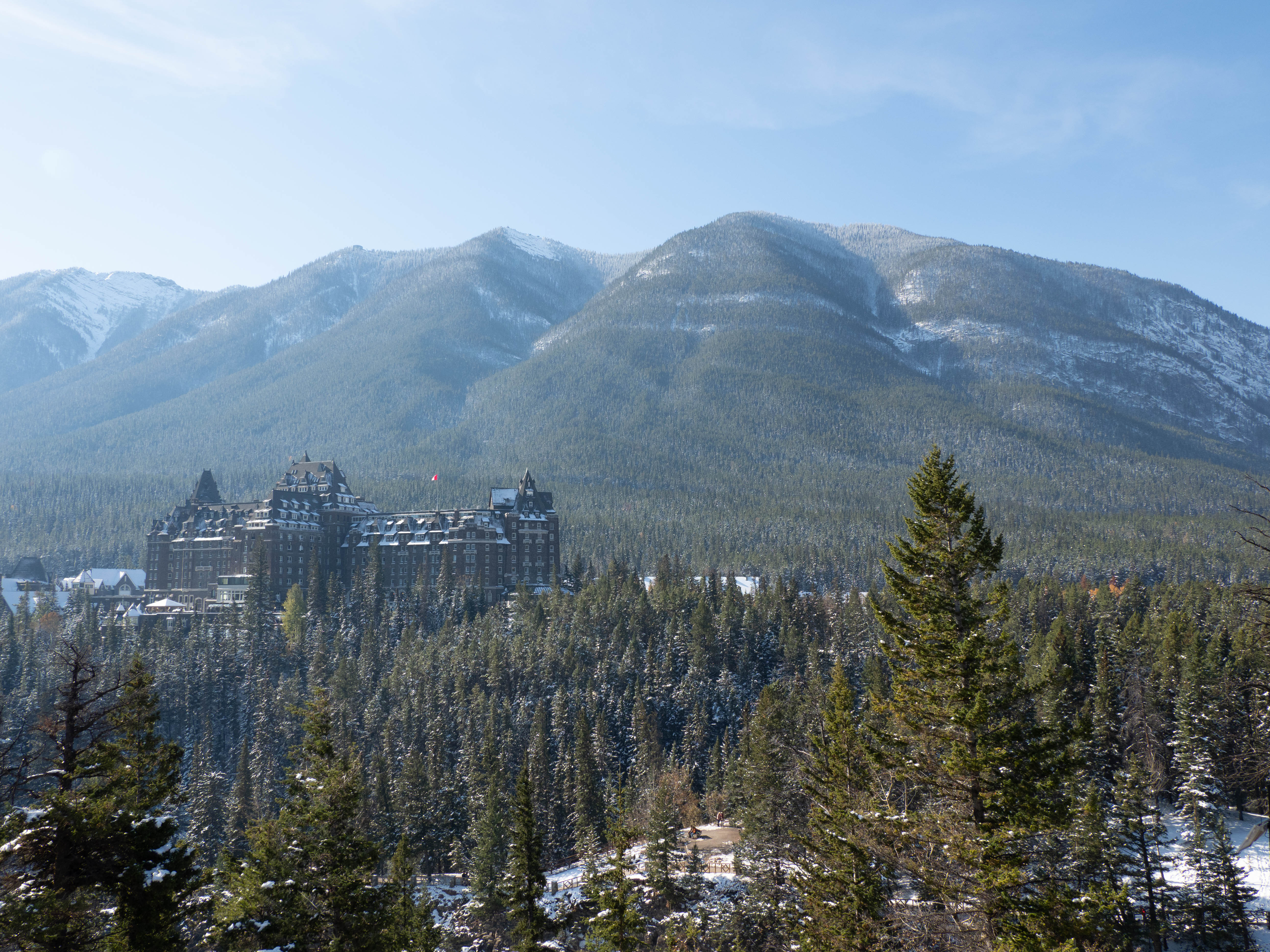 The historic Fairmont Banff Springs Hotel nestled among snow‑dusted pine forests and mountain peaks.